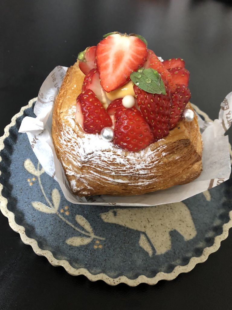 モンサンクレール デニッシュセゾン苺
粉糖をかけられた四角いデニッシュの上に、カットしたイチゴがいくつも積み上げられ、一番上の苺は断面がみずみずしく光っている。