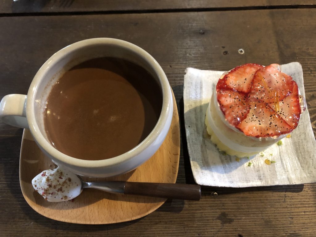 カフェラテ スプーンに生クリーム（スパイス付き）添え、苺のショートケーキ（丸い形で、薄切りの苺が重ねられた上をジュレが覆っている）