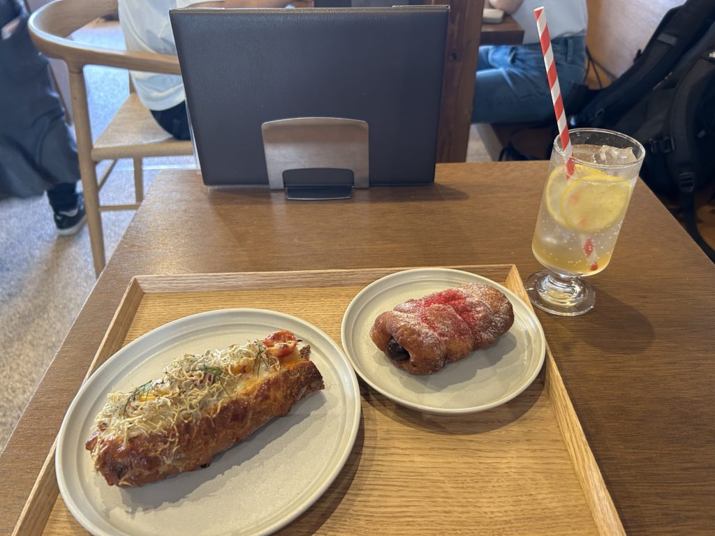 買ったパン2つとレモネードソーダ。ストローが赤と白の縞々。