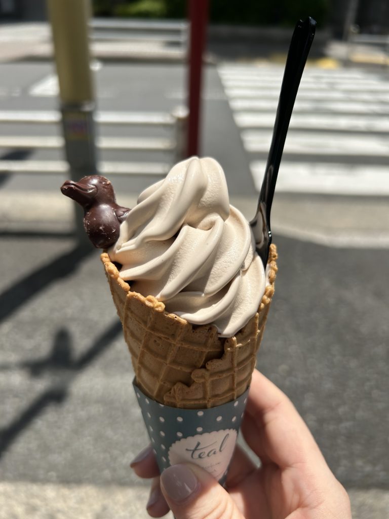 アマゾンカカオのミルクソフトクリーム。ほんのり色づいた茶色で、端に鴨のチョコレートが添えられている。