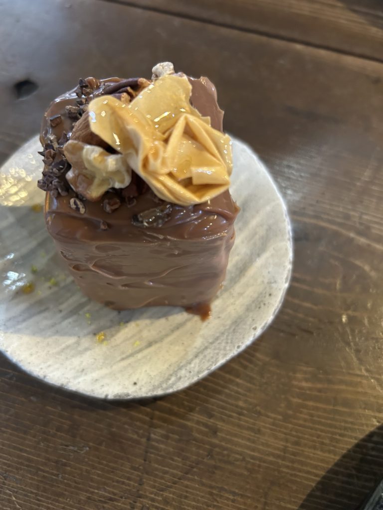 ジャンドゥーヤ。直方体型で、ねっとりしたクリームのため、表面が時折波立ったり角立ったりしている。上には、くしゅくしゅにしたパリパリのクレープ、カカオニブ、胡桃が乗っている。