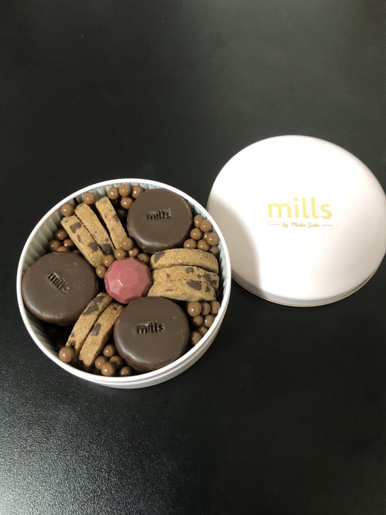 丸い缶の真ん中に、フランボワーズの宝石を模したタブレット、周囲をチョコチップクッキーとビターチョコレートでコーティングしたクッキーが囲み、隙間をミルクチョコレートのパフで埋めている。