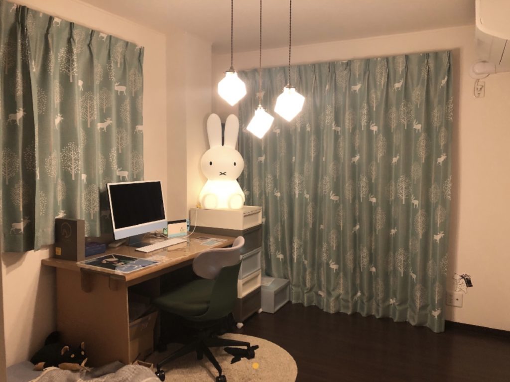 部屋の写真。
天井はキューブ型のペンダントライト3灯。
奥にタンスに乗ったミッフィーライト（XL）、机・パソコン、手前に布団が少しだけ見える。