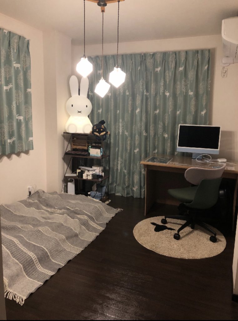部屋の写真。左側に置いていた机一式を右側に移動させ、机があった位置に布団を持ってくる。