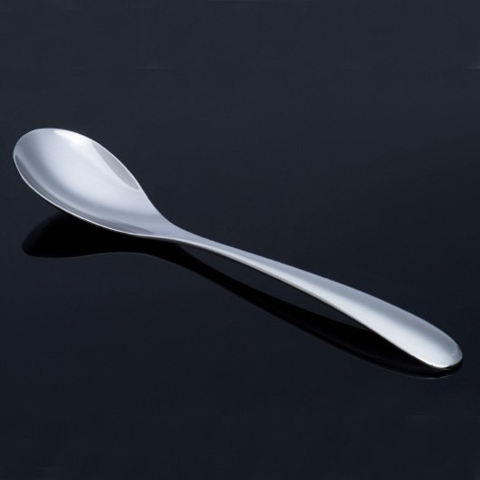 銀色のスプーン。カレーを食べるのに適したデザインにしている。