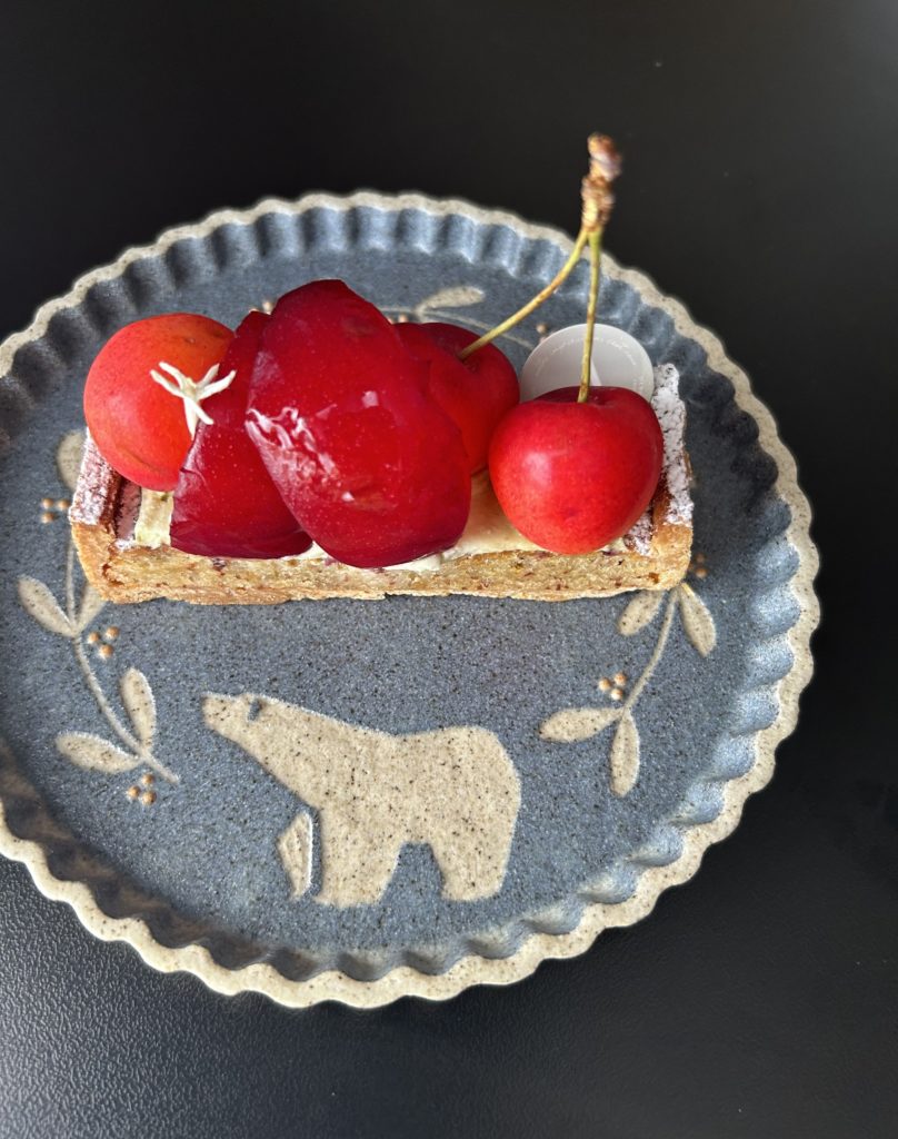 季節のタルト。長方形のタルト生地に、佐藤錦とスモモが乗っている。鮮やかな赤と真紅。