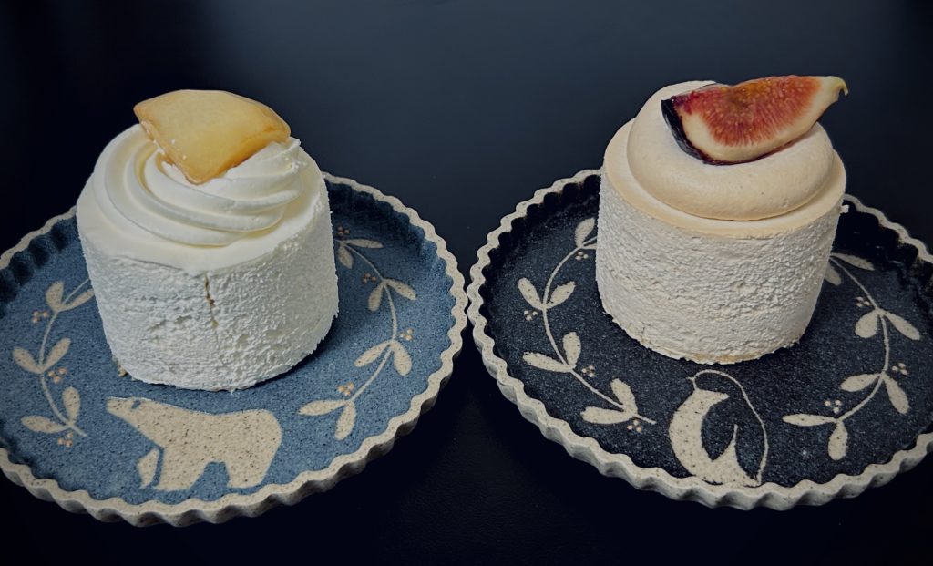 桃のショートケーキと、いちじくと紅茶のショートケーキ。円柱型のケーキの上にクリームを絞り、その上に大きく切った果物を一つ乗せている。