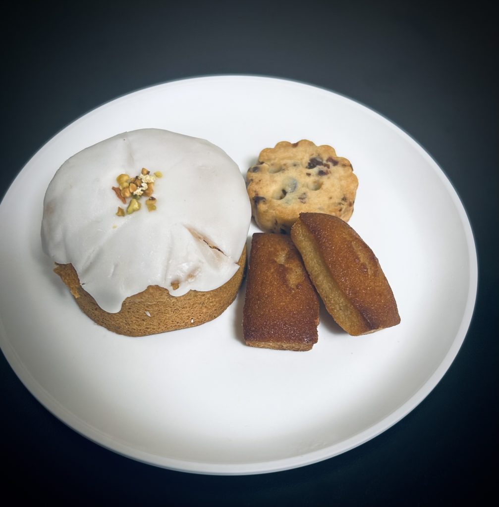 レモンとカルダモンとピスタチオのケーキ（左）。円型のパウンドケーキにレモンのアイシングと砕いたピスタチオ。
小さいフィナンシェとチョコチップサブレ（右）。