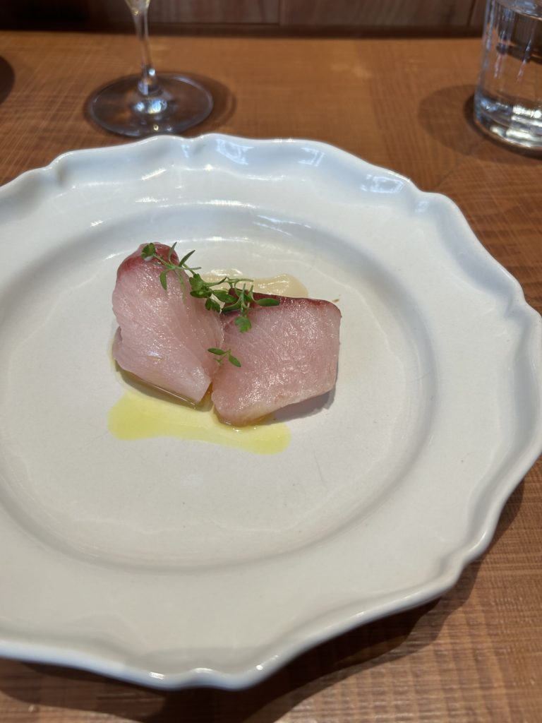 寒ブリの刺身。下に根セロリのスライスとペーストがあり、一緒に食べる。オイルはマドラスというカレーに使われるようなスパイスの風味。